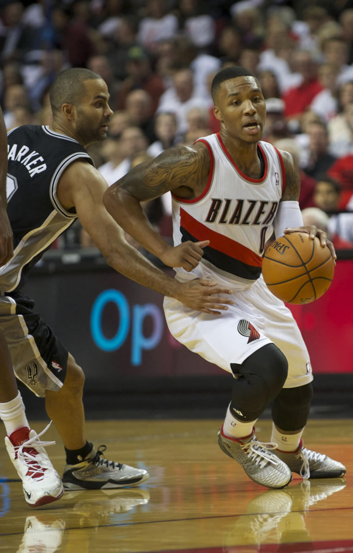 Portland Trail Blazers Damian Lillard drives past San Antonio's Tony Parker at the Moda Center, Saturday, November 2, 2013.