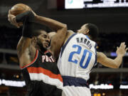 Portland Trail Blazers forward LaMarcus Aldridge, left, grabs an offensive rebound in front of Dallas Mavericks' Devin Harris (20) during the first half Saturday.