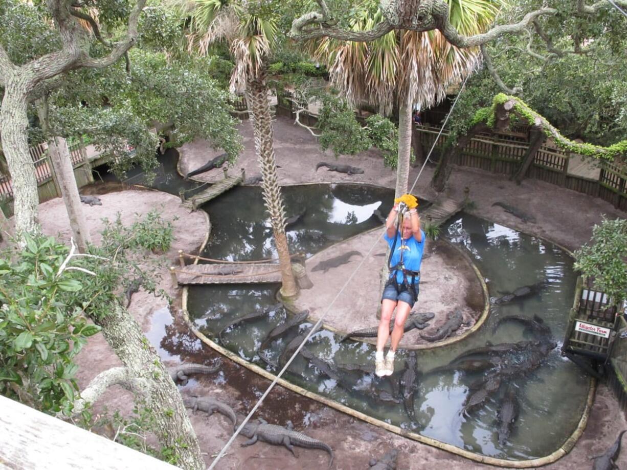 Ava Martin zip lines over an alligator lagoon at the St. Augustine Alligator Farm in St. Augustine, Fla.