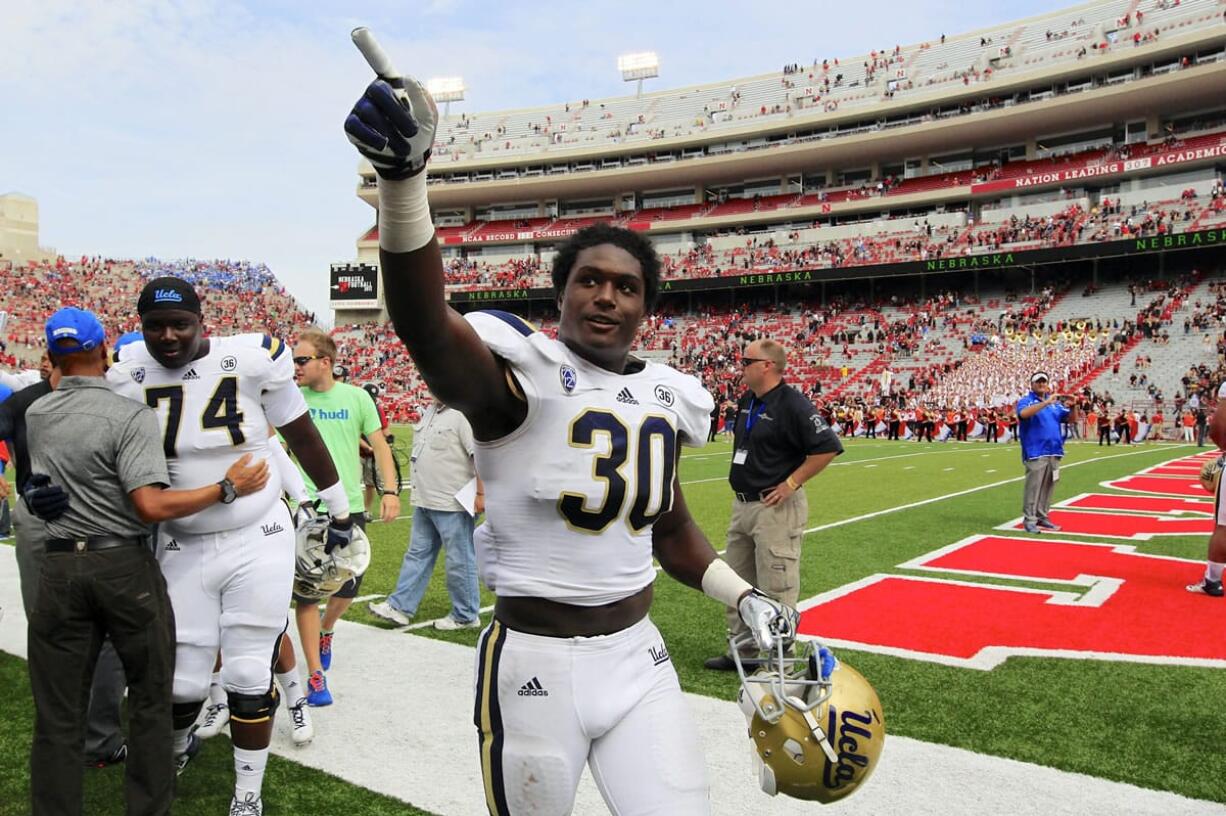 FILE - In this Sept. 14, 2013, file photo, UCLA linebacker Myles Jack (30) celebrates a 41-21 win over Nebraska in an NCAA college football game in Lincoln, Neb. Although Myles Jack is one of the nation's top young linebackers, it turns out the UCLA freshman is also pretty good with the ball in his hands. Jack gained 120 yards in just six carries against Arizona, and the 13th-ranked Bruins just might put him back in the backfield Friday against Washington.