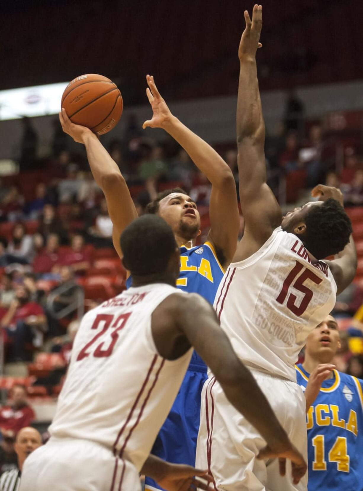 UCLA guard Kyle Anderson, center, shoots over Washington State forward Junior Longrus (15) as forward D.J. Shelton (23) watches during the first half of an NCAA college basketball game Saturday, March 8, 2014, at Beasley Coliseum in Pullman, Wash.