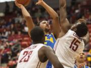 UCLA guard Kyle Anderson, center, shoots over Washington State forward Junior Longrus (15) as forward D.J. Shelton (23) watches during the first half of an NCAA college basketball game Saturday, March 8, 2014, at Beasley Coliseum in Pullman, Wash.