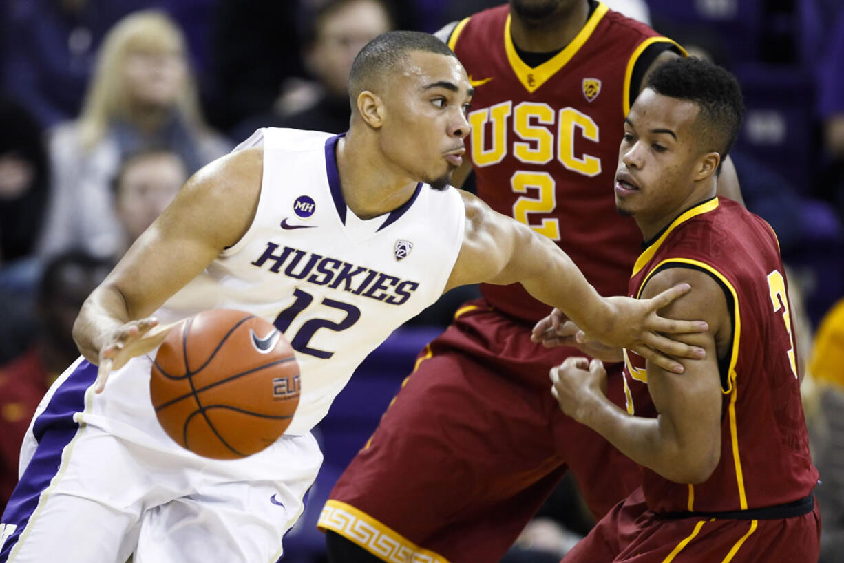 Washington guard Andrew Andrews (12) dribbles past Southern California guard Chass Bryan (3) during the first half of an NCAA college basketball game, Saturda in Seattle.