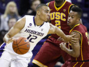 Washington guard Andrew Andrews (12) dribbles past Southern California guard Chass Bryan (3) during the first half of an NCAA college basketball game, Saturda in Seattle.