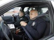 Nick Ut/Associated Press
Los Angeles police officers Adrian Garcia, right, and his partner Christopher Ballerini buckle their seat belts Tuesday as they prepare to leave the LAPD's Pacific Division for patrol in Los Angeles.