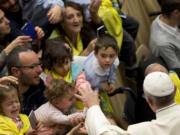 Pope Francis greets children Nov. 12 in the Pope Paul VI hall, at the Vatican. Pope Francis is writing a children&#039;s book.