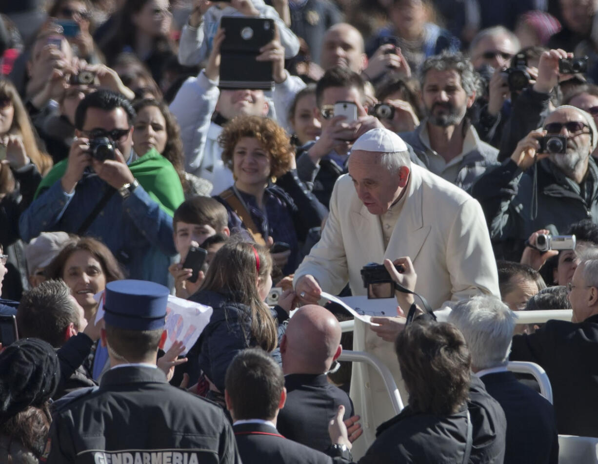 Pope Francis is presented with a drawing by a girl while touring St.