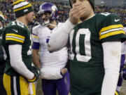 Green Bay Packers' Matt Flynn (10) covers his face as Scott Tolzien (16) talks to Minnesota Vikings' Christian Ponder after an NFL football game Sunday, Nov. 24, 2013, in Green Bay, Wis. The game ended in a tie, 26-26.