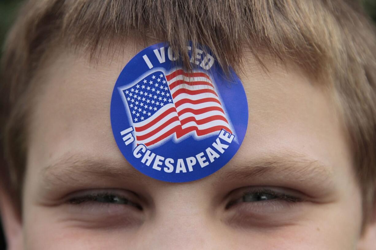 Colby Black, 10, poses for a portrait outside of the Centerville Chapel A.M.E Church in Chesapeake, Va., where his grandmother, Terry DeRoche, cast her vote on Tuesday.