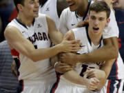 Gonzaga's David Stockton, right, is mobbed by teammates at the end of a quarterfinal West Coast Conference NCAA college basketball tournament game against Santa Clara, Saturday, March 8, 2014, in Las Vegas. Stockton hit a basket to put Gonzaga up by two points with one second left on the clock. Gonzaga won 77-75.