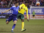 United States Geoff Cameron, left, challenges St. Vincent and the Grenadines Gavin James for the ball during the first half of a 2018 World Cup qualifying soccer match Friday, Nov. 13, 2015, in St. Louis.