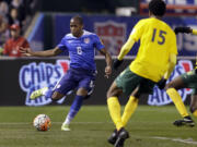 Darlington Nagbe, left, controls the ball as St. Vincent and the Grenadines Kevin Francis (15) defends during the second half of a 2018 World Cup qualifying soccer match Friday, Nov. 13, 2015, in St. Louis. The United States won 6-1.