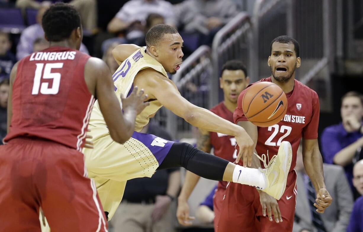 Washington's Andrew Andrews, center, tries to block a pass from Washington State's Royce Woolridge (22) to Junior Longrus (15) during the first half Friday.