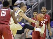 Washington's Andrew Andrews, center, tries to block a pass from Washington State's Royce Woolridge (22) to Junior Longrus (15) during the first half Friday.