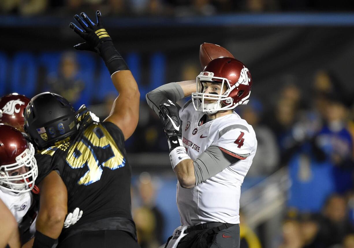 Washington State quarterback Luke Falk, right, passes under pressure from UCLA defensive lineman Matt Dickerson during the first half of an NCAA college football game, Saturday, Nov. 14, 2015, in Pasadena, Calif. (AP Photo/Mark J.