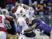 Washington&#039;s Cory Littleton, right, dislodges the ball from Washington State quarterback Peyton Bender (6) during the second half Friday.