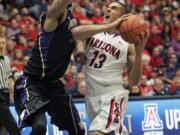 Arizona's Nick Johnson (13) tries to shoot against the pressing defense of Washington's Desmond Simmons, left, in the first half of Saturday's Pac-12 Conference game at Tucson, Ariz.