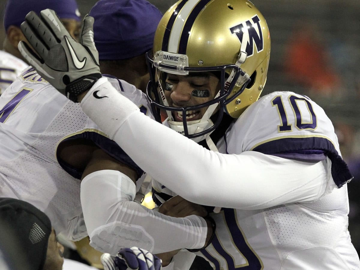 Washington quarterback Cyler Miles hugs a teammate on the bench during the second half against Oregon State on Saturday. Miles passed for 162 yards and one touchdown as they beat Oregon State 69-27.