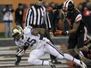 Washington running back Bishop Sankey, left, dives in for a touchdown past Oregon State defender Tyrequek Zimmerman during the first half of an NCAA college football game in Corvallis, Ore., Saturday, Nov. 23, 2013.