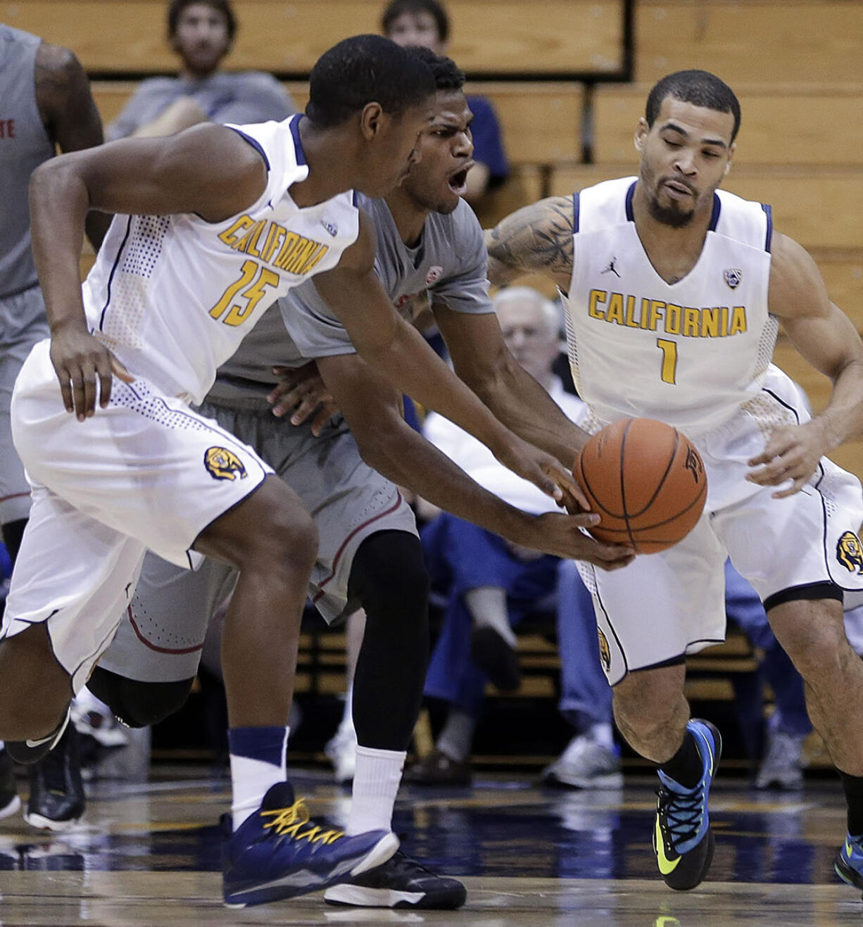 Washington State's Royce Woolridge, center, chases a loose ball with California's Jordan Mathews (15) and Justin Cobbs (1) during the first half Saturday at Berkeley, Calif.