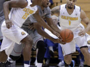 Washington State's Royce Woolridge, center, chases a loose ball with California's Jordan Mathews (15) and Justin Cobbs (1) during the first half Saturday at Berkeley, Calif.