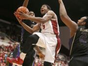 Stanford's Chasson Randle (5) drives to the basket against Washington's Mike Anderson, left, and Perris Blackwell (2) during the second half Saturday at Stanford, Calif. Stanford won 79-67.