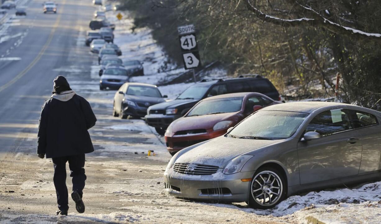 FILE - In this Thursday, Jan. 30, 2014, file photo, cars abandoned during an earlier snowstorm sit idle along Northside Parkway in Atlanta. With memories of thousands of vehicles gridlocked for hours on icy metro Atlanta highways fresh in their minds, emergency officials and elected leaders in north Georgia were preparing Monday, Feb. 10, 2014, for another round of winter weather.