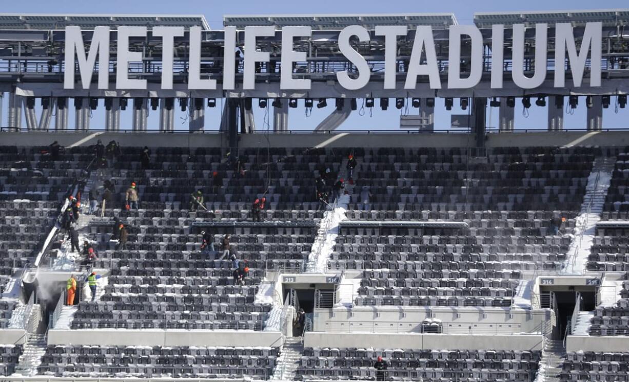 Workers shovel snow off the seats at MetLife Stadium as crews removed snow ahead of Super Bowl XLVIII following a snow storm on Wednesday in East Rutherford, N.J.