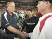 Mike Holmgren, left, shakes hands with Arizona head coach Ken Whisenhunt after Holmgren's final game coaching the Seahawks on Dec.