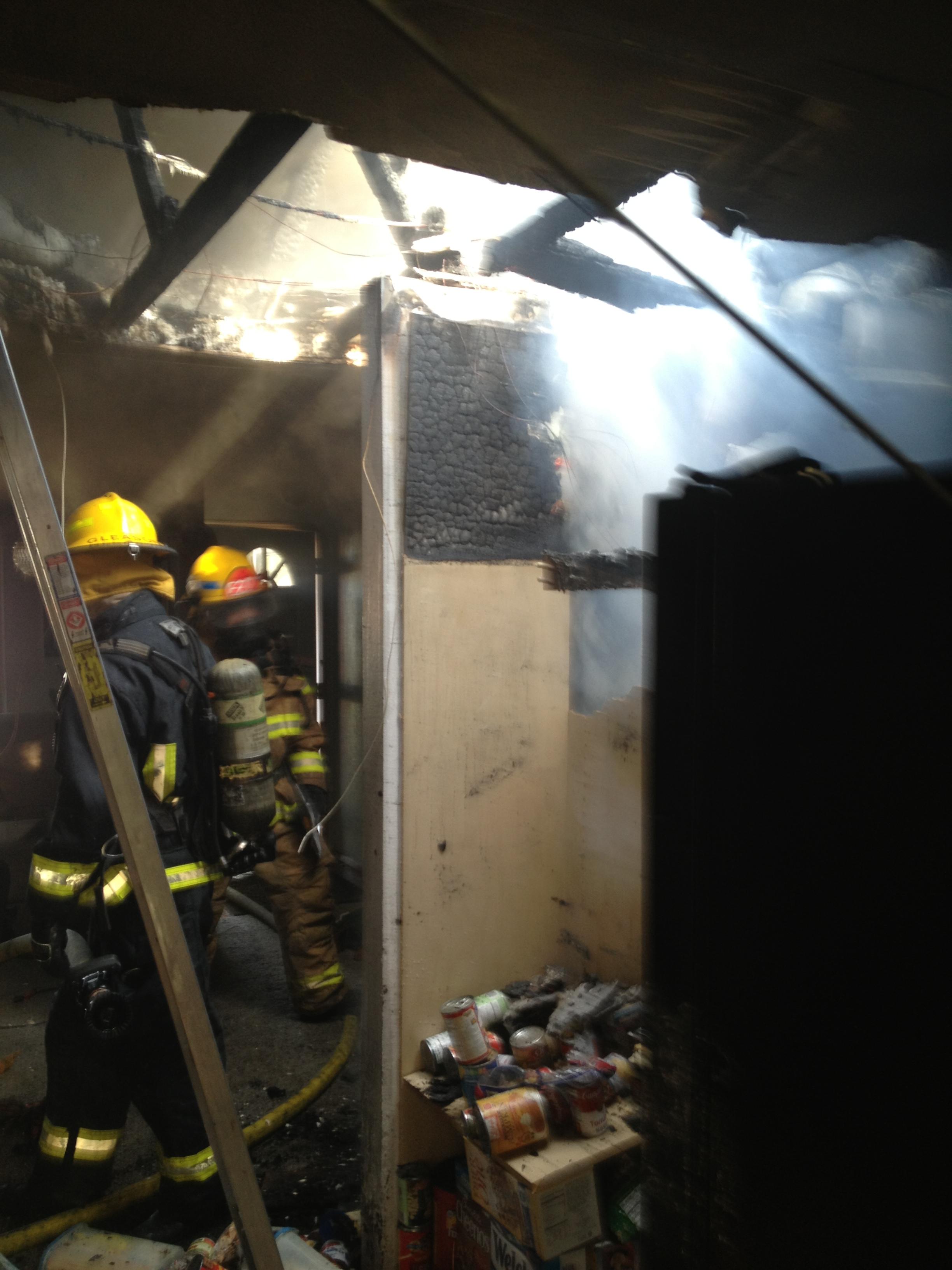 Firefighters work inside a house in Battle Ground that was extensively damaged by an attic fire Saturday.