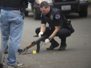 Vancouver Police investigate the scene where a man fired shot from an assault rifle on the 100 block of West 30th Street on Wednesday.