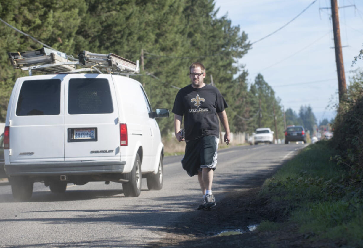 A pedestrian walks on a dirt path in the glass along Southeast First Street in east Vancouver last month.