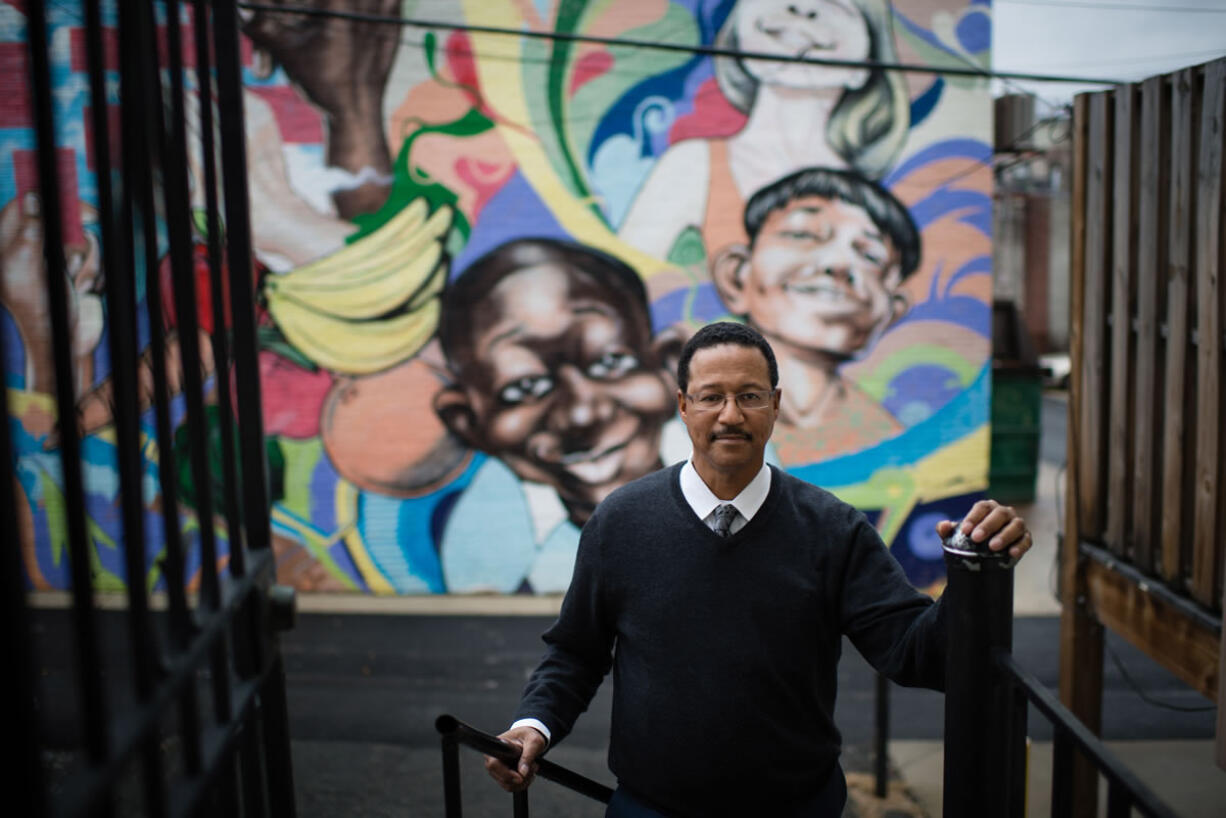 Lawrence Taylor is a job counselor at Jubilee Jobs in Washington. The Move Up program at Jubilee Jobs helps people transition from entry-level jobs into positions that make a livable wage. A mural is painted on the building behind his workplace. (Sarah L.