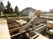 Curtis Karlsen of Pahlisch Homes helps build a house last month in Vancouver.