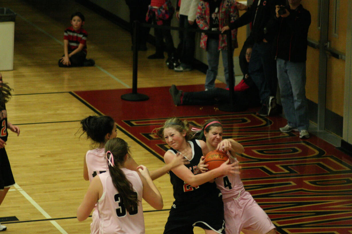 Camas Papermakers Kimi Knight, Brenna Khaw and Nikki Corbett surround a Battle Ground Tiger during the Hoops for Pink game Friday night, in the Camas warehouse.