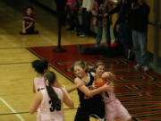 Camas Papermakers Kimi Knight, Brenna Khaw and Nikki Corbett surround a Battle Ground Tiger during the Hoops for Pink game Friday night, in the Camas warehouse.