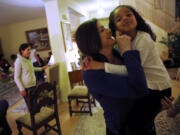 Minoo Panahi holds her niece Isabelle Placide, 5, during a Baha'i devotional in the home of a family member on Jan.