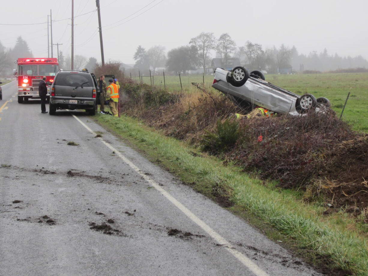 Clark County Fire &amp; Rescue firefighters respond to the scene of a single-car crash, where a Ridgefield High School student rolled her car.