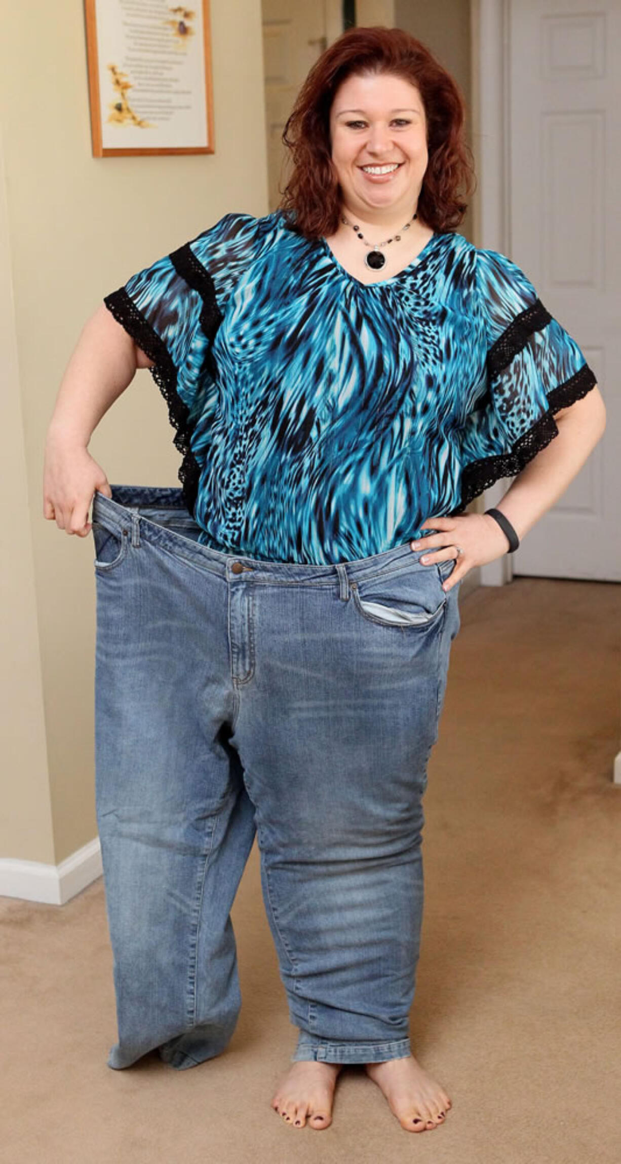 Kristy Olds of Loganville, Georgia, poses for a photo in her old jeans on January 4, 2013. Olds lost 191 pounds.