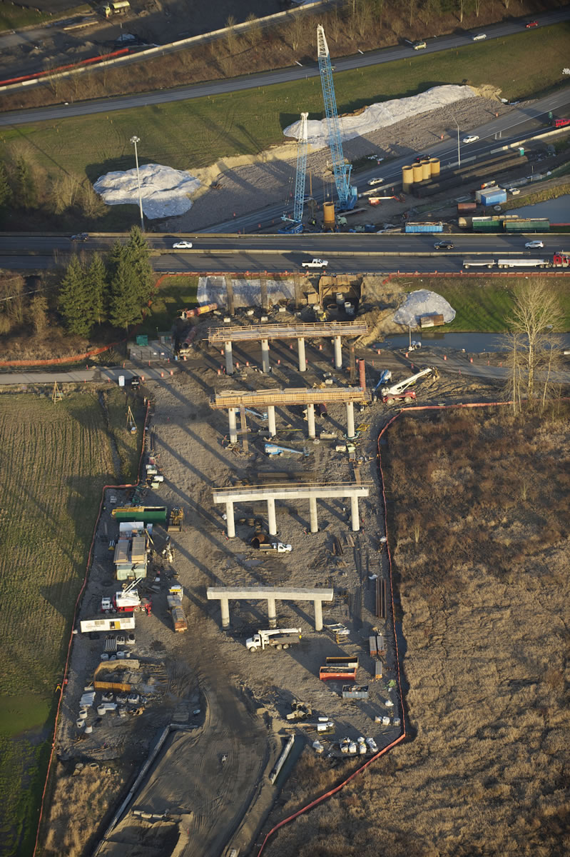 Contractors for the Washington State Department of Transportation are transforming the look of the area where Interstates 5 and 205 join, in the Salmon Creek area north of Vancouver. Piers that will carry the new Northeast 139th Street overpass over the traffic lanes are under construction on the west side of Interstate 5, in the foreground of this photo, which looks east. The storm drainage pond beyond the highway on the right edge of the photo is on the site of the old Salmon Creek Park &amp; Ride lot, which was closed for wetlands mitigation. The $133 million project will offer motorists an east-west alternative to Northeast 134th Street in the busy corridor that includes Washington State University Vancouver, Legacy Salmon Creek Medical Center, the new Park &amp; Ride, and the Salmon Creek Community Library.