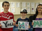 Jemtegaard Middle School students (left to right) Corey Barton, Casey Schulenbarger and Kim Kanning hold signs which accompany a poem for their anti-bullying performance, based on the T.V.