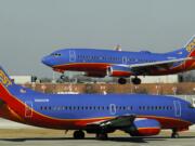 A Southwest Airlines Boeing 737 waits to take off at Chicago's Midway Airport as another lands.