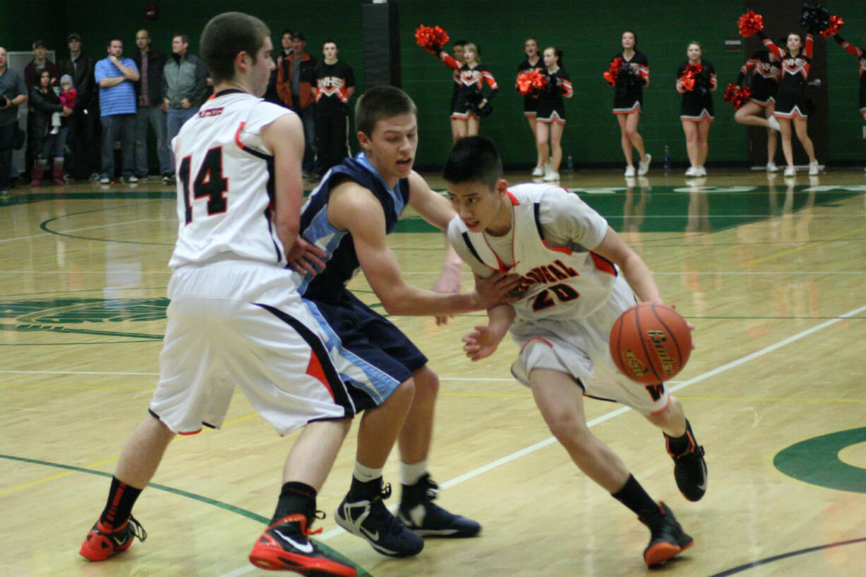 Sean Guthrie sets a screen for Austin Tran during the consolation finals of the district tournament Feb. 19, at Evergreen High School.