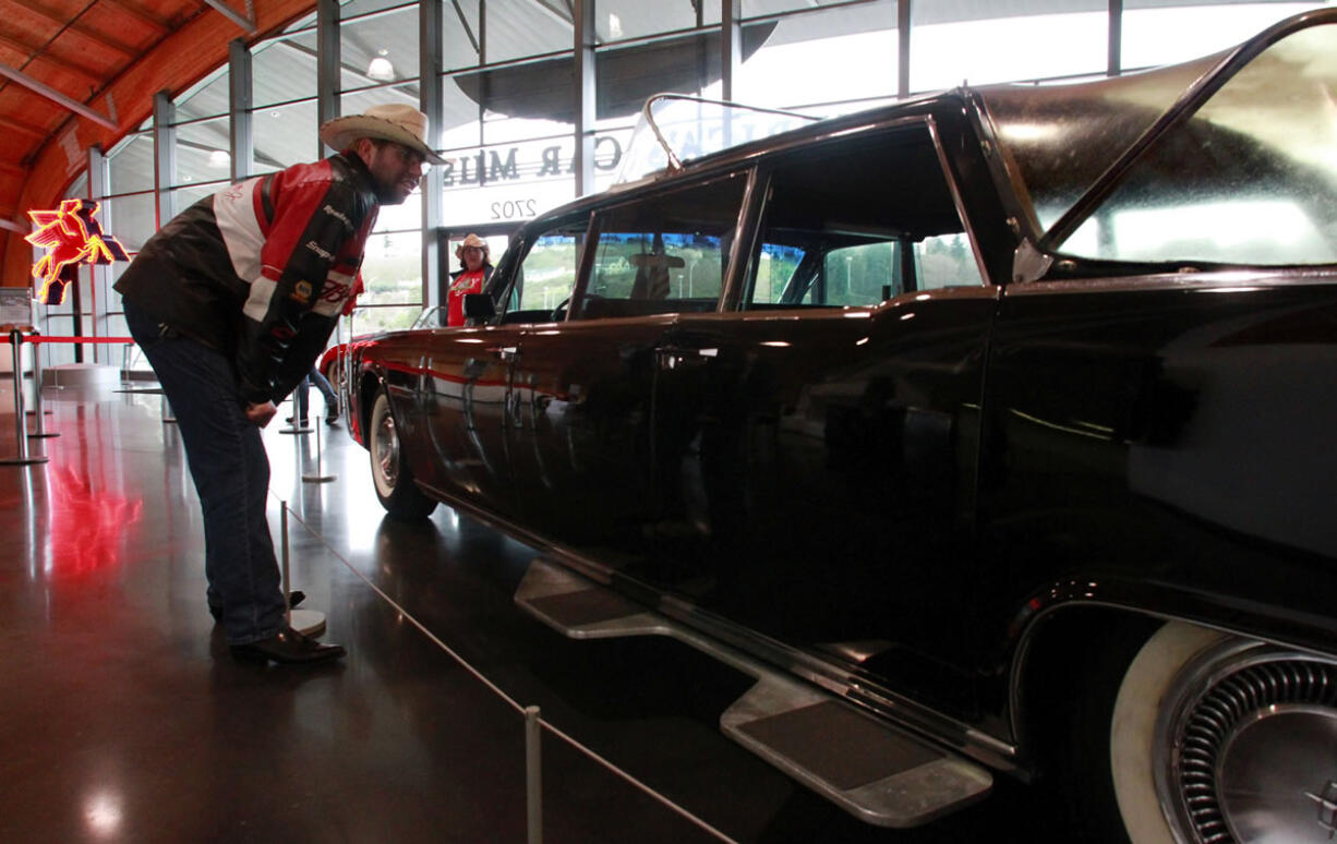 Mark McNeely checks out the 1964 Lincoln Continental limousine modified for Pope Paul VI's visit to New York City on display at the LeMay automobile museum in Tacoma.