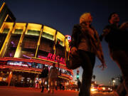 People walk in front of the Regal Cinemas LA Live Stadium 14 in Los Angeles.