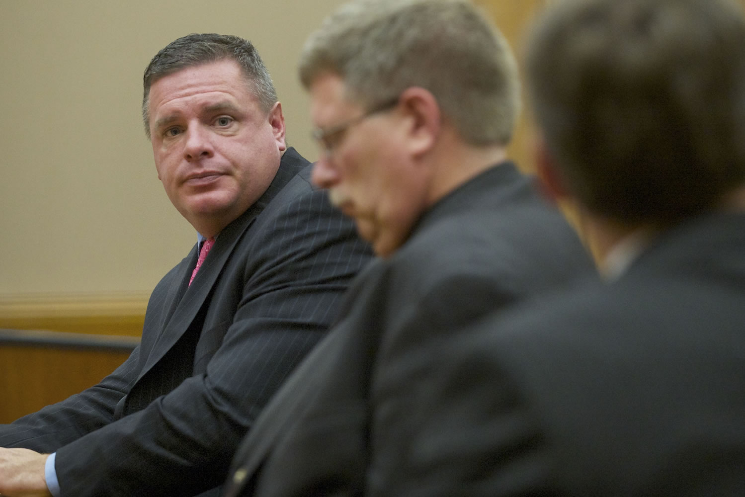 Skamania County's former auditor, John Michael Garvison, left, listens to attorneys during an Oct.