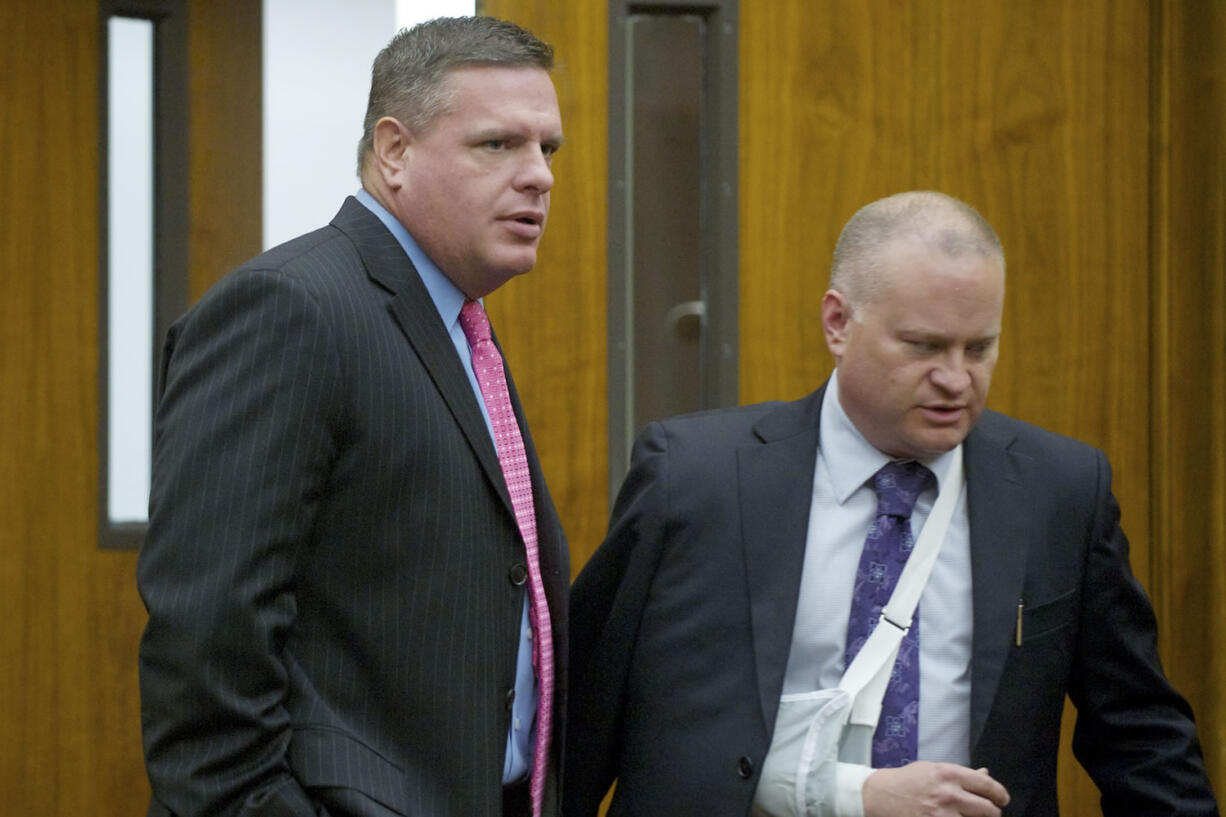 Skamania County's former auditor, John Michael Garvison, left, enters Clark County Superior Court Judge Barbara Johnson's courtroom with his attorney Jon McMullen on Oct.