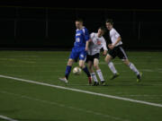 Washougal's Joesph Snedeker and Nicholas Boylan try to take the soccer ball away from Will Warne (19) of Mountain View Monday, at Fishback Stadium.