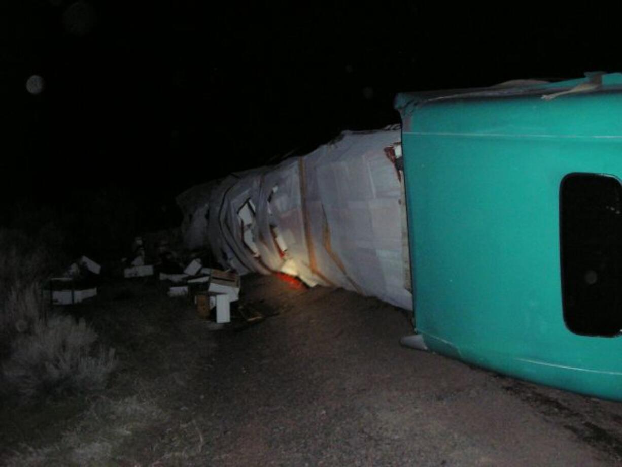 A tractor-trailer rig lies on its passenger side after running off Highway 97 in Central Oregon Saturday.