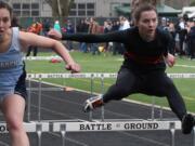 Washougal High School senior Kari Johnson (right) and a Mark Morris Monarch go toe-to-toe in the 100-meter hurdles at the Tiger Invitational Saturday, at Battle Ground High School.